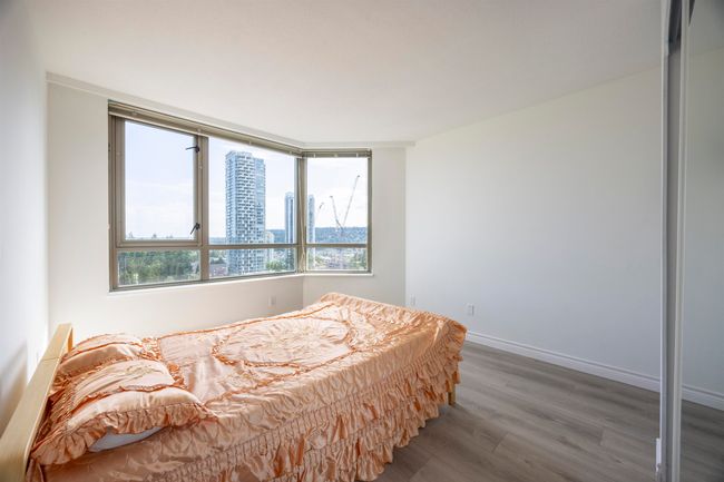 Bedroom with wood finished floors and a view of city | Image 13