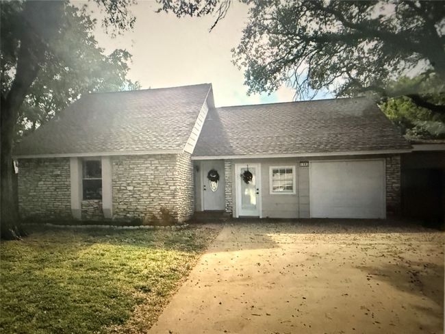 View of front of home with an attached garage, stone siding, roof with shingles, and driveway | Image 4