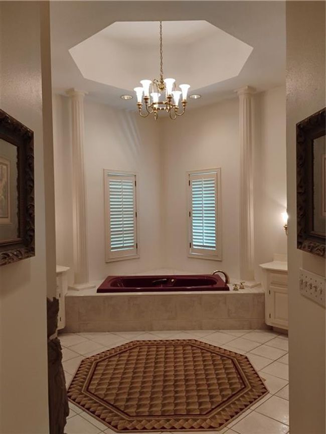 Bathroom with decorative columns, vanity, tile patterned flooring, and a notable chandelier | Image 47