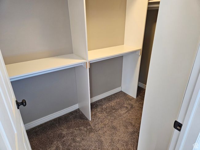 Walk in closet featuring dark carpet | Image 39