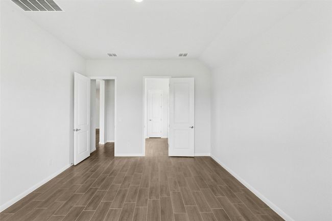Unfurnished bedroom with baseboards and dark wood-style flooring | Image 10