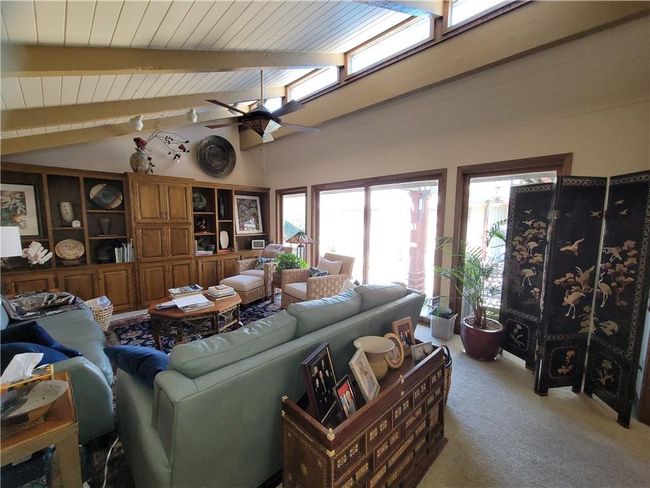 Living room featuring vaulted ceiling with beams, ceiling fan, wood ceiling, and light colored carpet | Image 21