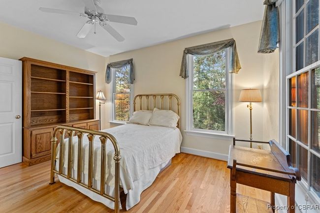 Bedroom with light wood finished floors and a ceiling fan | Image 36