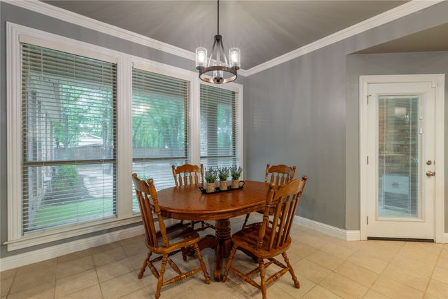 Dining room featuring a chandelier, ornamental molding, and light tile patterned flooring | Image 17