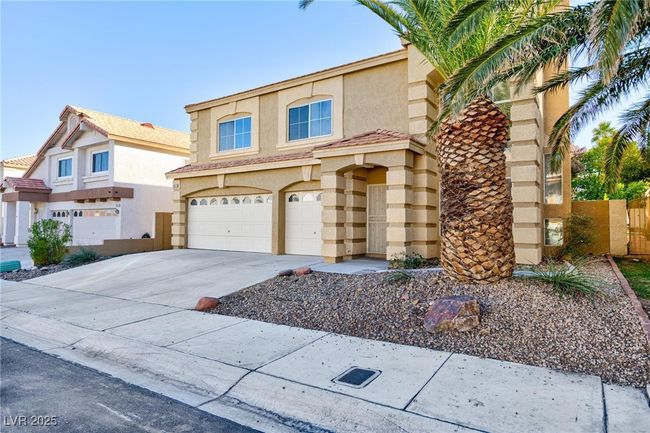 View of front of home with an attached garage, driveway, stucco siding, and fence | Image 41
