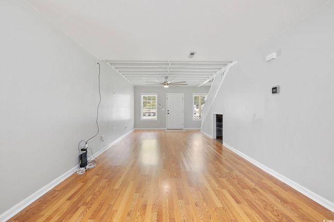 Unfurnished living room featuring a ceiling fan, light wood-style flooring, baseboards, and a fireplace | Image 25