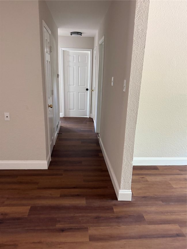Hallway with baseboards and dark wood finished floors | Image 7