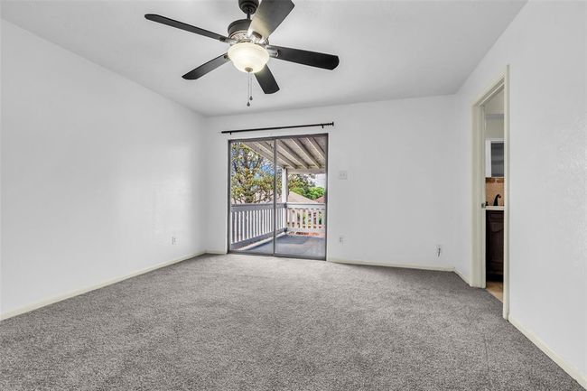 This primary bedroom on the second floor has direct access to the balcony. The door on the right leads to the bathroom and walk-in closet. | Image 18