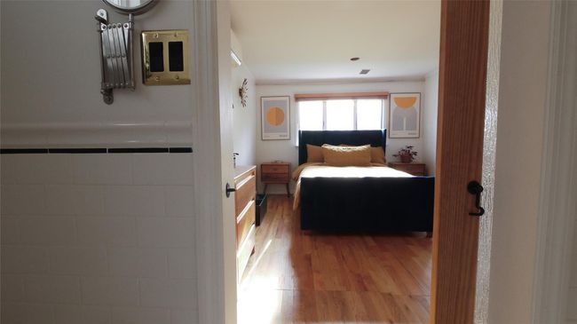 Bedroom with wood finished floors and crown molding | Image 16