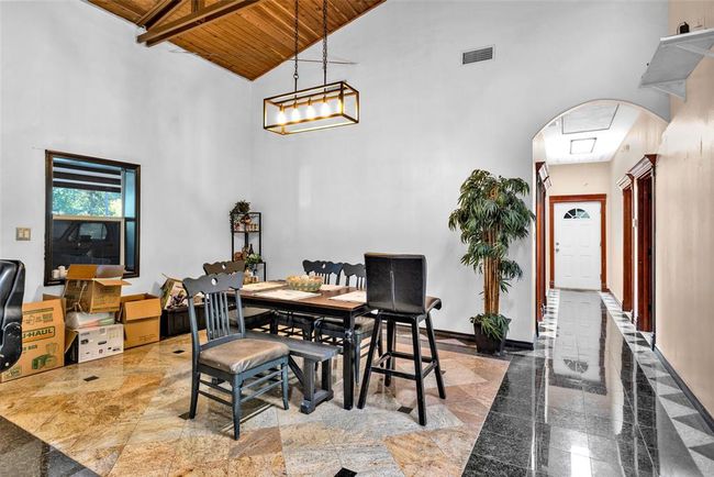 Hallway to the right leads to three bedrooms, a bathroom and door to the garage | Image 18