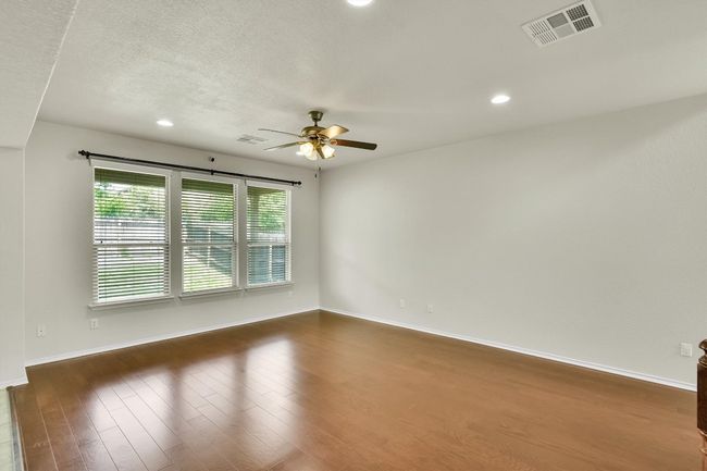 Spare room with dark wood finished floors, ceiling fan, baseboards, and visible vents | Image 7