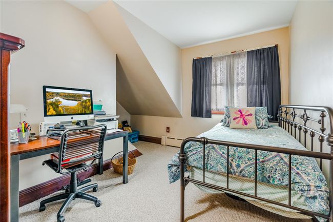 Bedroom featuring a baseboard heating unit, baseboards, and carpet floors | Image 23