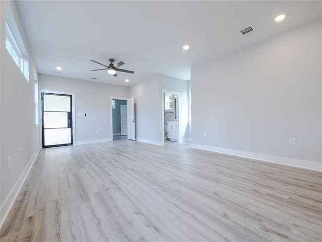 Unfurnished living room with light wood-type flooring, a ceiling fan, and recessed lighting | Image 9