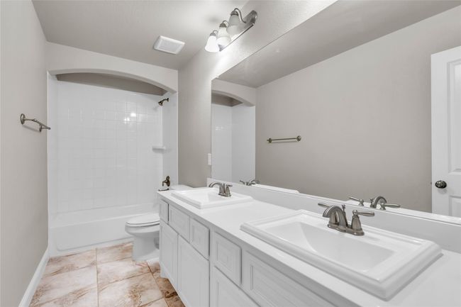 Bathroom with toilet, double vanity, shower combination, and baseboards | Image 28