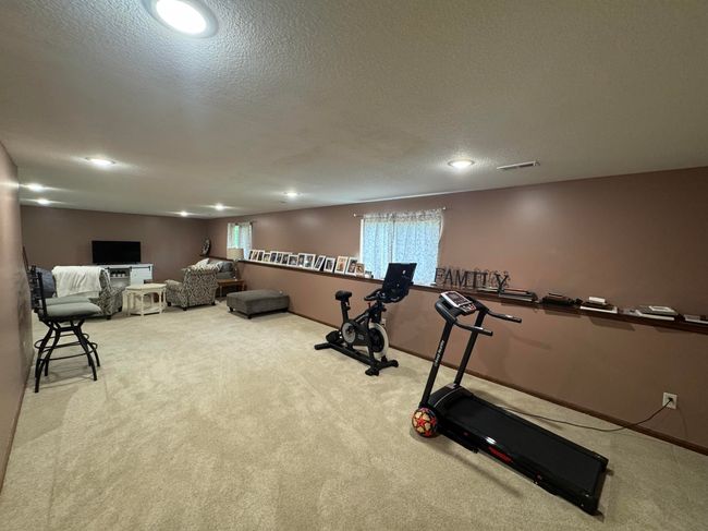 Exercise room featuring carpet flooring, a textured ceiling, and recessed lighting | Image 23