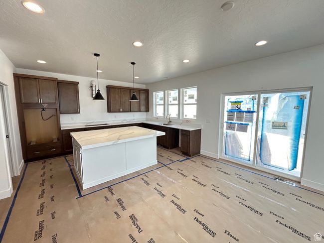 Kitchen featuring recessed lighting, a center island, dark brown cabinets, stovetop, and hanging light fixtures | Image 5