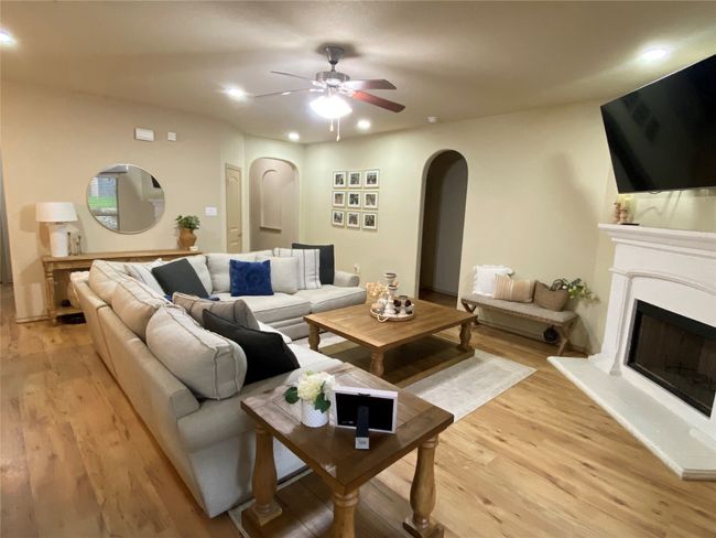 Living room with a ceiling fan, arched walkways, and luxury vinyl plank wood-style floors | Image 14
