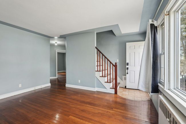 Entrance foyer featuring stairs, hardwood / wood-style flooring, baseboards, and radiator | Image 4