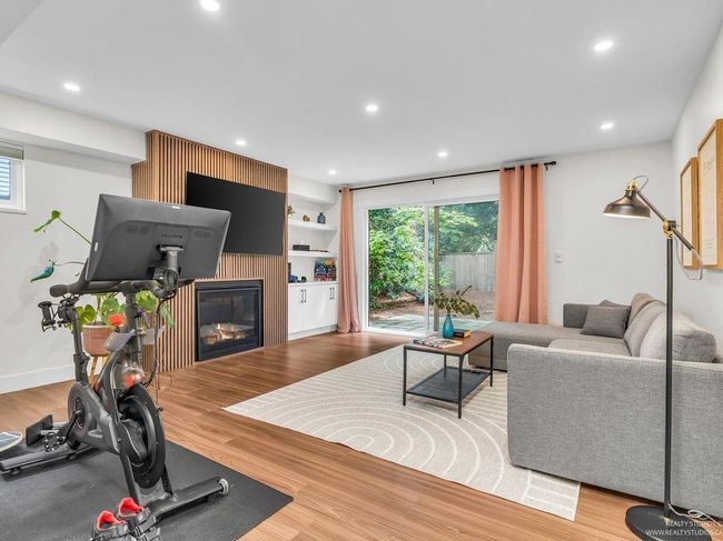 Beautiful newly renovated family room with gas fireplace and statement fireplace surround, built in display shelves as well as enclosed shelving for storage, and beautiful new flooring, all with patio doors to the back yard. | Image 22