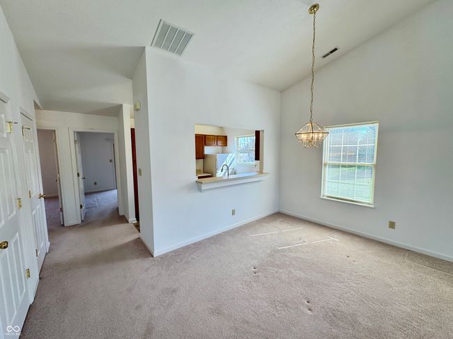 interior space with light carpet, visible vents, baseboards, and an inviting chandelier | Image 4