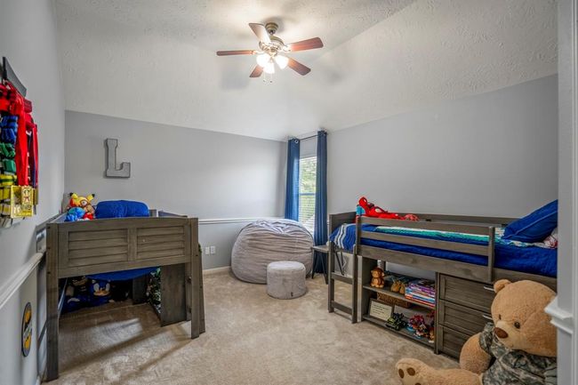This spacious secondary upstairs bedroom offers plenty of room to spread out, featuring vaulted ceilings and charming chair railing. The large walk-in closet provides ample storage space, making this room as functional as it is beautiful. | Image 27
