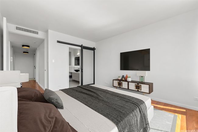 Bedroom features new custom made door and barnyard door to bathroom. Virtually Staged(enhanced) | Image 13