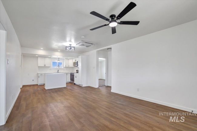 Unfurnished living room featuring dark wood-style floors, a ceiling fan, and recessed lighting | Image 12