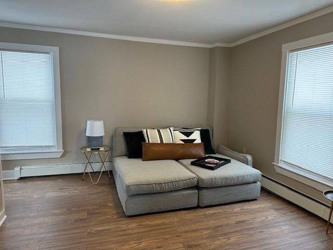 Sitting room featuring hardwood / wood-style floors, a baseboard radiator, and ornamental molding | Image 13