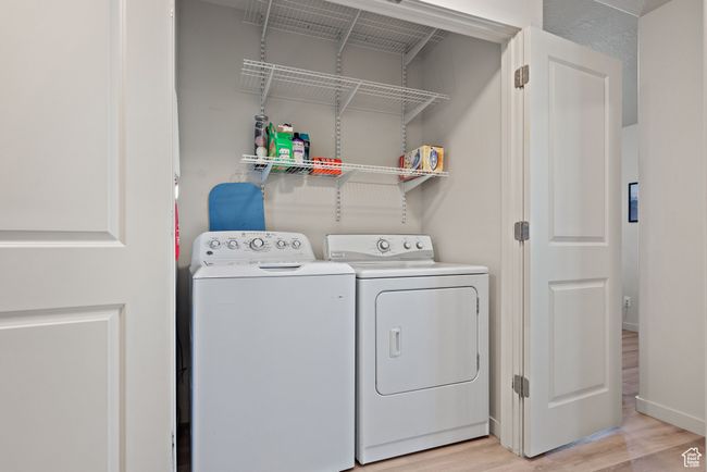 Laundry room with washer and dryer and light wood finished floors | Image 11