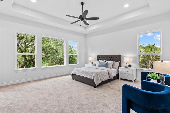 Primary bedroom with windows framing large oaks outside | Image 13