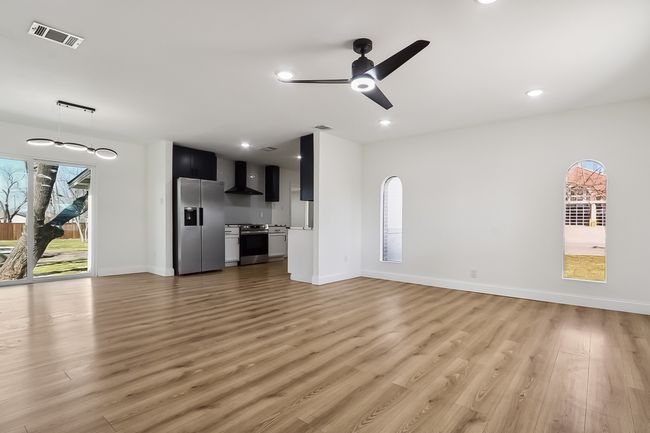 Unfurnished living room featuring recessed lighting, visible vents, ceiling fan, and light wood finished floors | Image 4