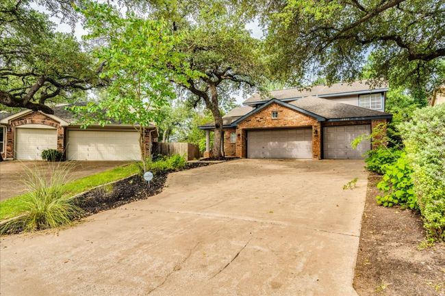 View of front of property with concrete driveway, a shingled roof, a garage, fence, and brick siding | Image 4