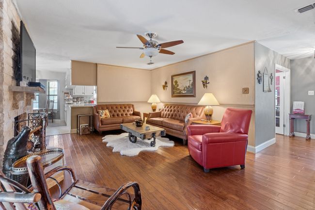 DEN featuring a fireplace, ceiling fan, and dark hardwood / wood-style flooring | Image 10