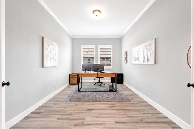 French doors leads you to a spacious office with elevated ceilings and plantation shutters | Image 32