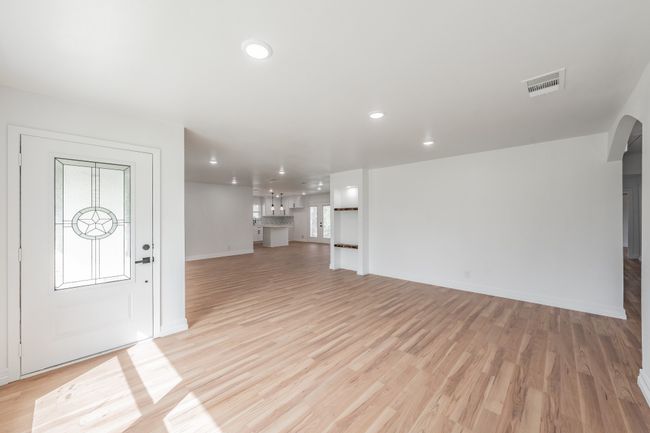 Unfurnished living room with recessed lighting, light wood-type flooring, arched walkways, and baseboards | Image 29