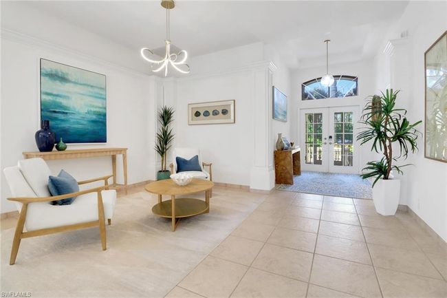 Living area featuring french doors, baseboards, tile patterned floors, and a notable chandelier | Image 5