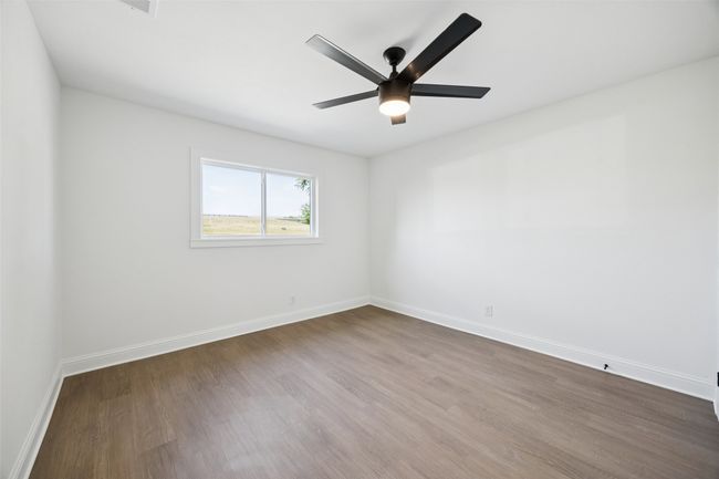 Unfurnished room featuring dark wood-type flooring and a ceiling fan | Image 10