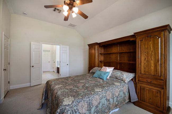 Bedroom with vaulted ceiling, light carpet, baseboards, and ceiling fan | Image 11