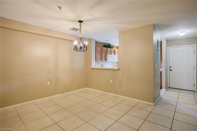 Unfurnished dining area featuring light tile patterned flooring and a chandelier | Image 4