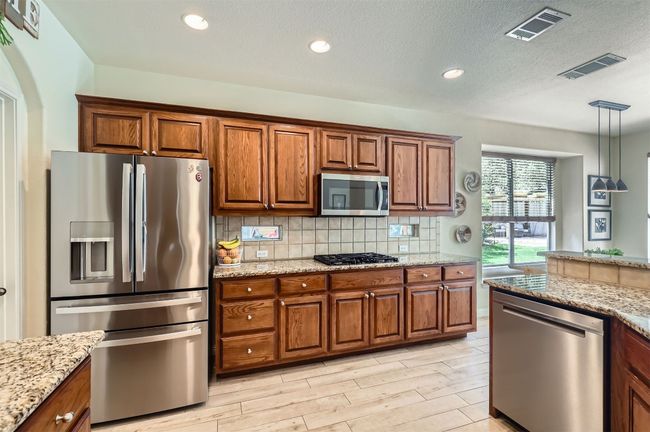 Well-equipped kitchen with gas cooktop and plenty of workspace. | Image 9