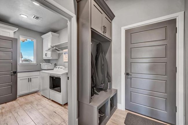 Mudroom featuring washing machine and clothes dryer and light wood finished floors | Image 26