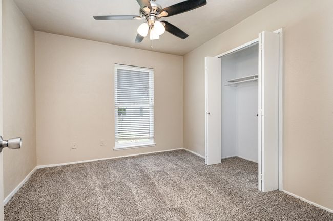 Unfurnished bedroom with light colored carpet, a closet, and ceiling fan | Image 21