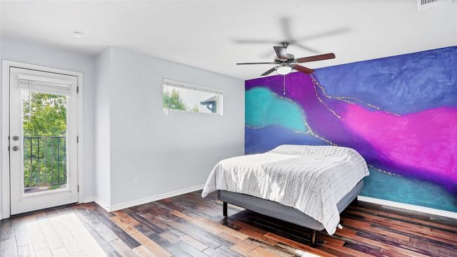 Bedroom featuring baseboards, wood finished floors, access to outside, and multiple windows | Image 17
