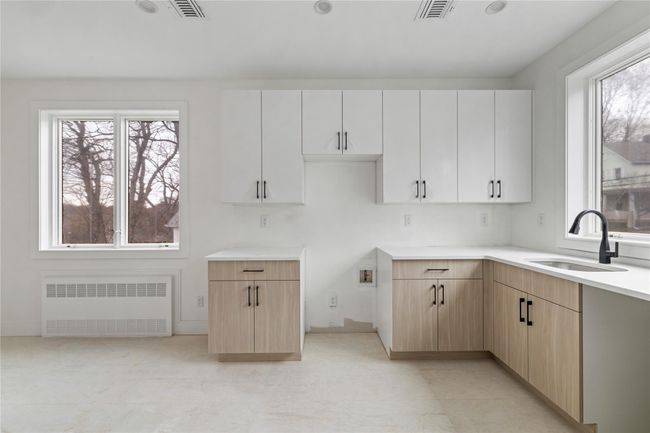 Kitchen with radiator, a sink, visible vents, and light countertops | Image 21