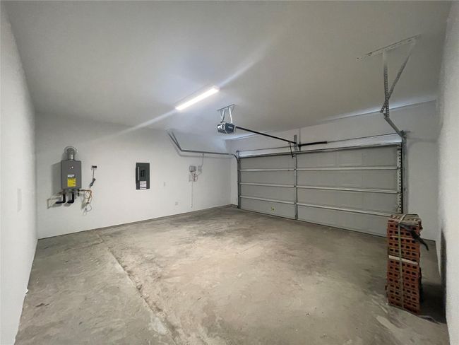 Garage featuring electric panel and a garage door opener | Image 35