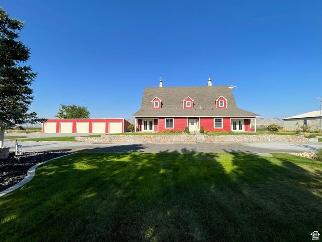 Cape cod house featuring a chimney, a front yard, and an outdoor structure | Image 7
