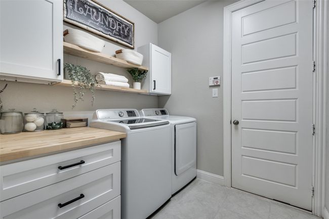 Laundry room featuring baseboards, independent washer and dryer, light tile patterned floors, and cabinet space | Image 21