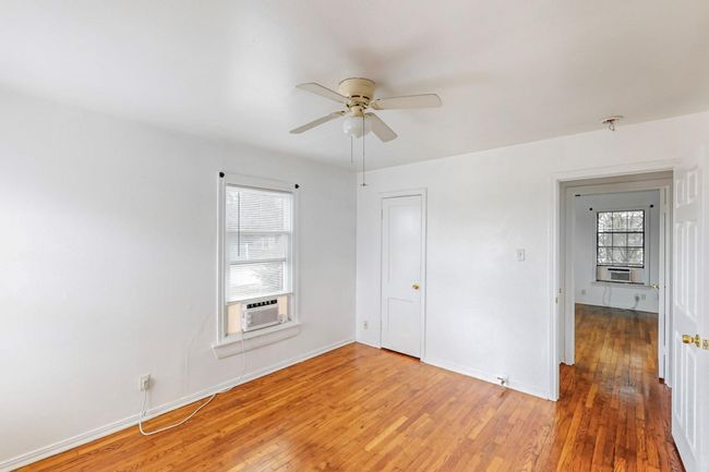 Unfurnished bedroom featuring multiple windows, light wood-style flooring, and ceiling fan | Image 13
