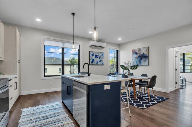Kitchen featuring a sink, stainless steel dishwasher, baseboards, dark wood-style flooring, and light countertops | Image 10