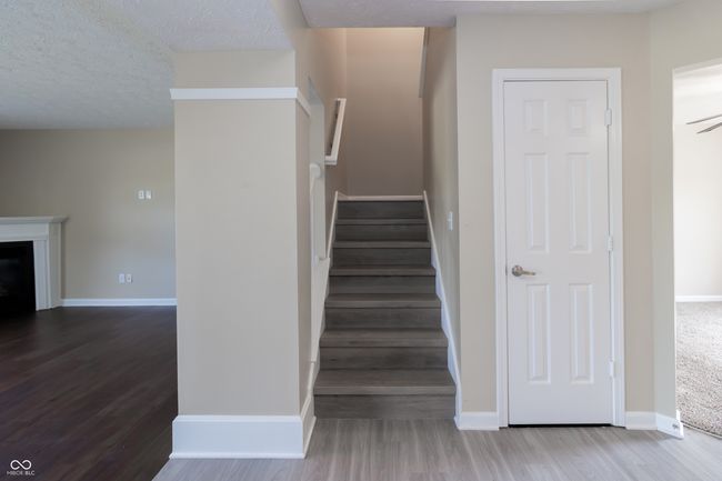 stairs with wood finished floors, a fireplace, and a textured ceiling | Image 8